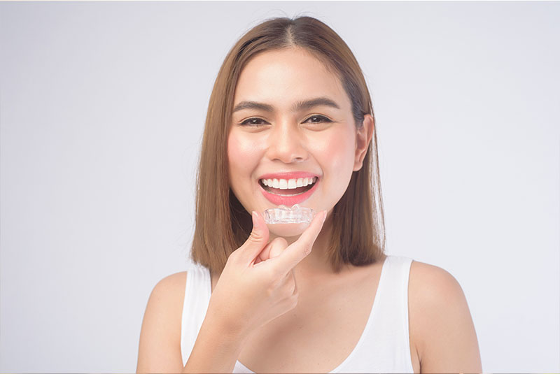 young women smiling brightly with their Invisalign