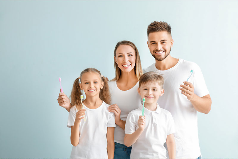 family taking a picture with toothbrushes