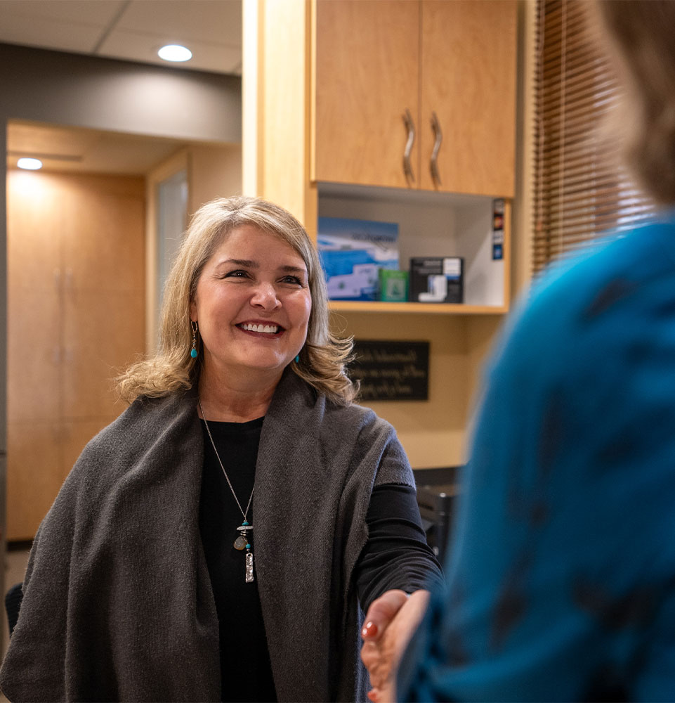 staff member helping patient at the front desk of the dental center