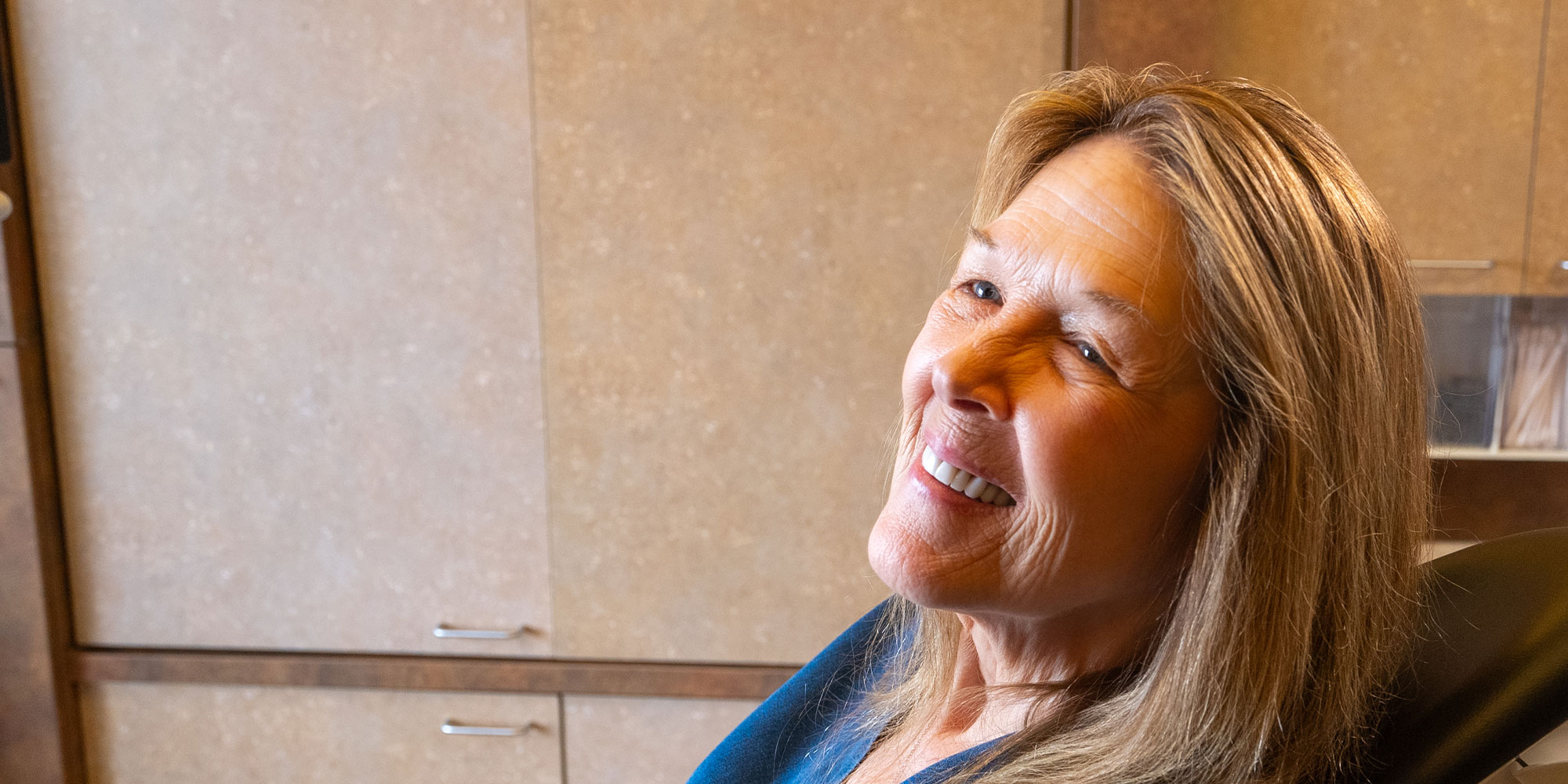 patient smiling brightly while inside of the dental center
