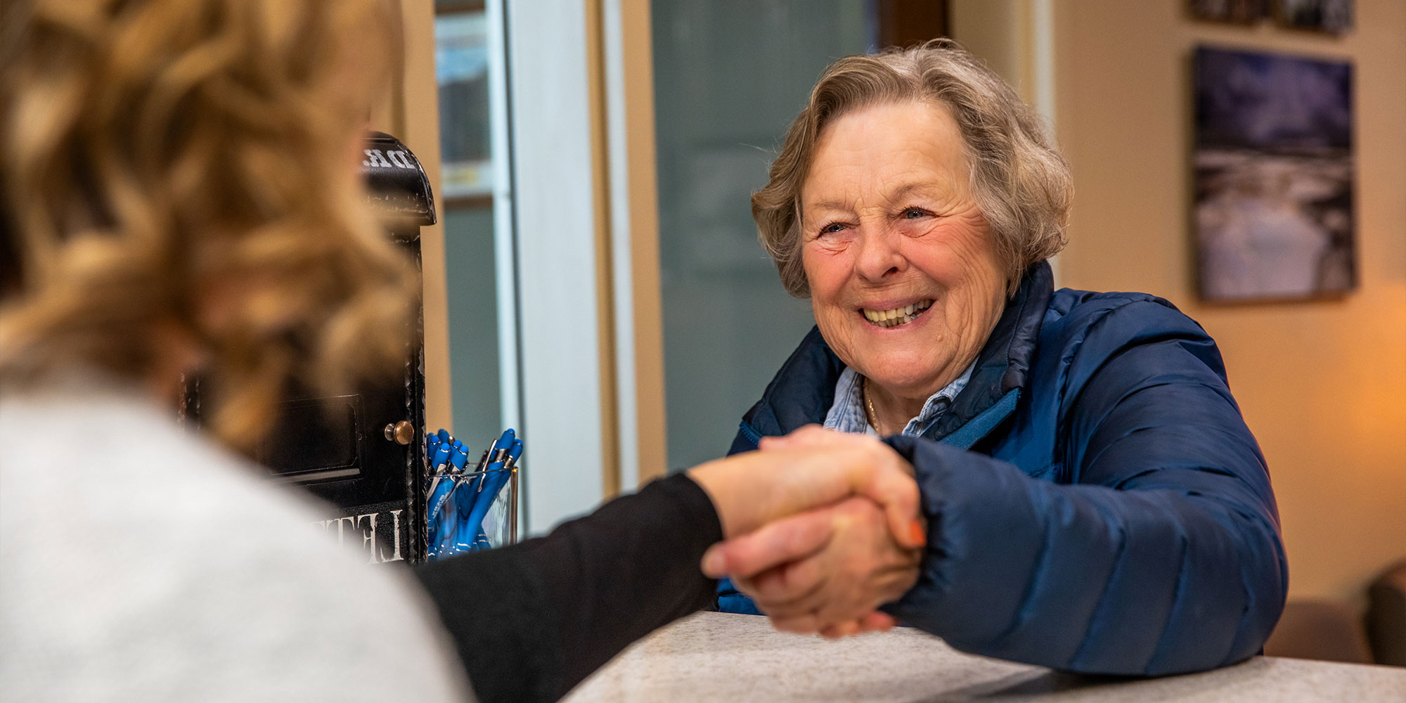 patient thanking staff member at the front desk of the dental center
