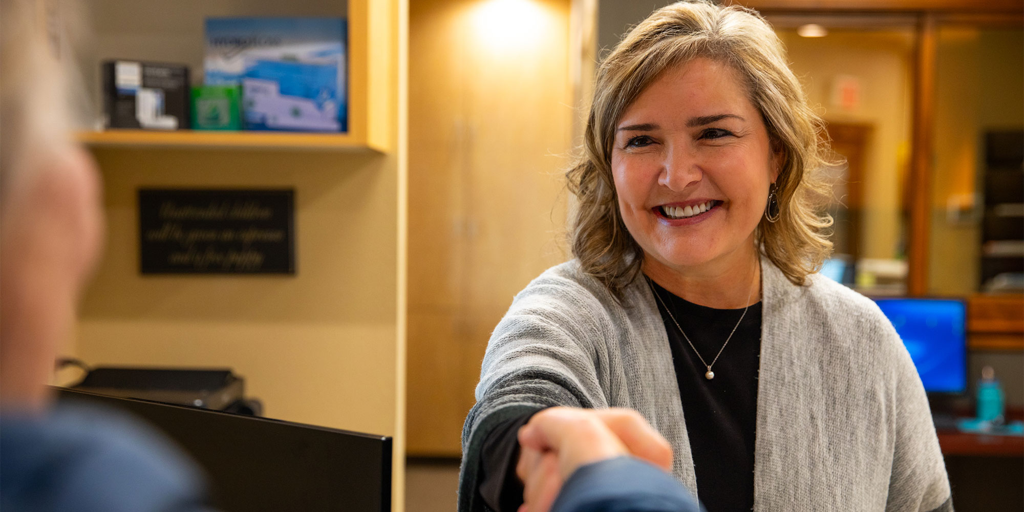staff member helping patient at the front desk