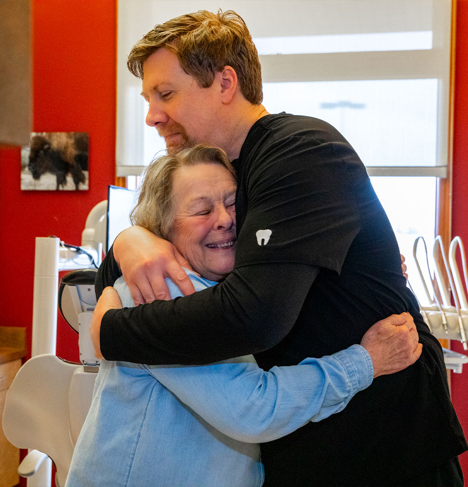 patient and doctor hugging warmly after patient's dental procedure